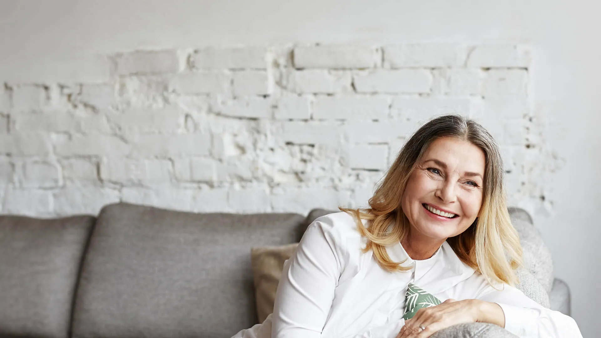 Charlotte Rampling sitting on a couch