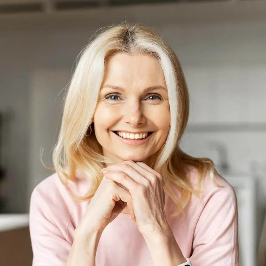 a woman smiling with her hand on her chin