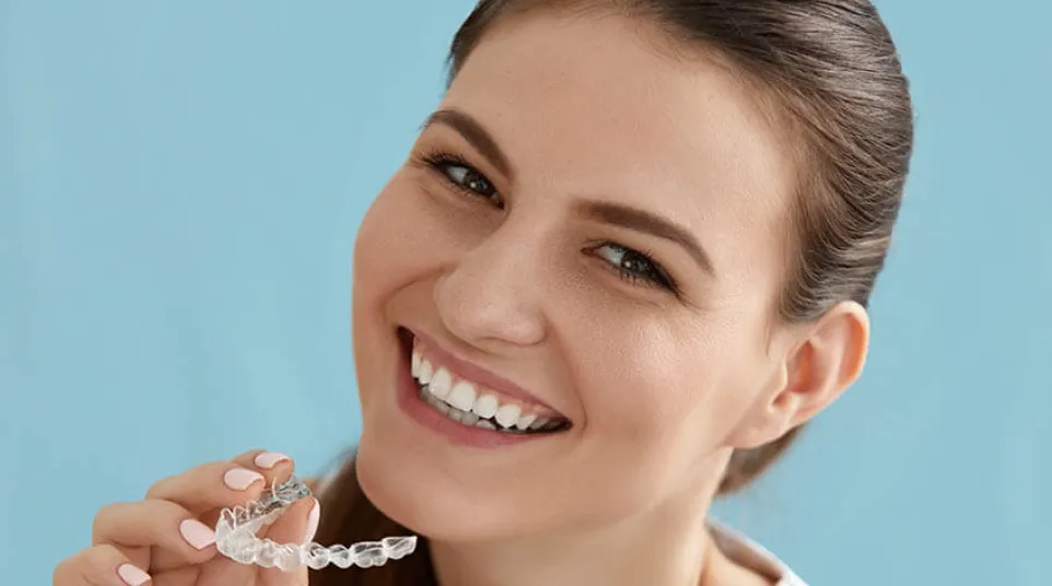 a woman smiling and holding a spoon
