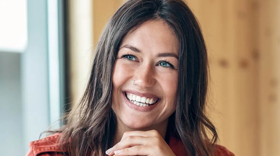 a woman smiling and holding her chin